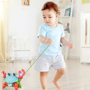 Criança brincando com o Caranguejo Fujão Musical colorido e interativo, puxando com a corda