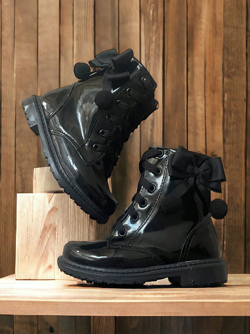 Coturno Infantil Feminino preto brilhante com laços e pompons, ideal para meninas estilosas