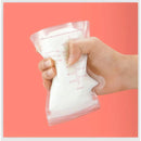 Mão segurando um saco de leite materno com medidor, parte do Kit 30 Sacos de Armazenamento de Leite Materno
