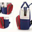 Mochila Maternidade Multifuncional com design moderno em vermelho, azul e branco, ideal para mães práticas